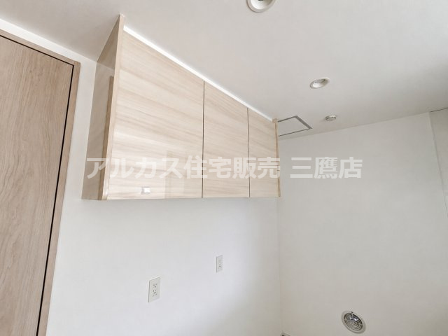 西東京市向台町2丁目 西武新宿線 田無駅 新築戸建てのキッチン|キッチン背面部分に設置された吊戸棚収納。木目調のデザインでインテリアに馴染み、食器や備品の整理に便利です。