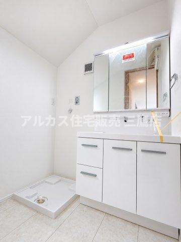 西東京市向台町2丁目 西武新宿線 田無駅 新築戸建ての独立洗面台|三面鏡裏収納を備えた清潔感のある洗面化粧台。横には洗濯機置き場が確保され、浴室への動線もスムーズな洗面所空間です。