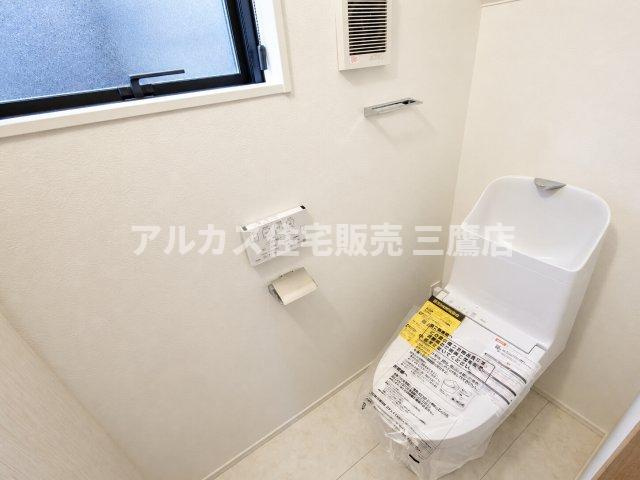 西東京市向台町2丁目 西武新宿線 田無駅 新築戸建てのトイレ|1階の温水洗浄便座付きトイレ。清潔感のある白を基調とした空間で、壁面にはリモコンやペーパーホルダー、タオル掛けがすっきりと配置されています。