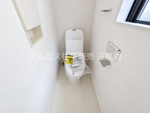 西東京市向台町2丁目 西武新宿線 田無駅 新築戸建てのトイレ|2階の温水洗浄便座付きトイレ。壁面埋込型の収納棚や小窓を備え、省スペースながら機能的な造りになっています。