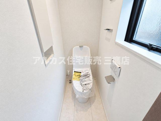 西東京市向台町2丁目 西武新宿線 田無駅 新築戸建てのトイレ|埋込型の収納棚や手すりホルダーを備えた機能的なトイレ。白を基調としたすっきりとしたデザインで、空間を広く見せる工夫が施されています。