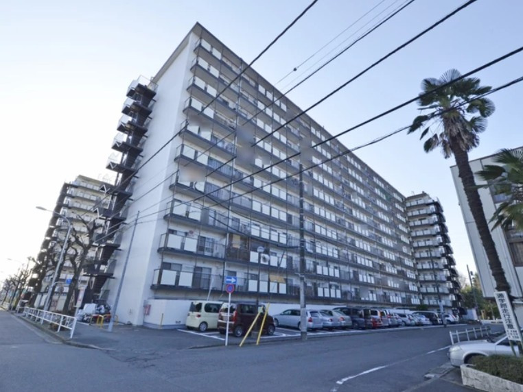 秀和めじろ台レジデンスの外観|敷地は三方向を接道した角地で、南側には前面道路の向こうに椚田公園の緑を借景。北側には隣接するスーパーをはじめ、商業施設が点在、大型スーパーへも徒歩5分ほどと、日常のお買い物に便利です。