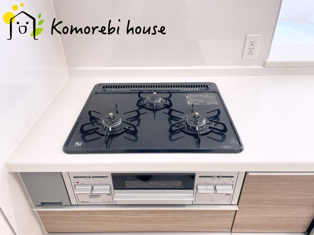 上尾市原市　新築一戸建て　ブルーミングガーデン　01のキッチン|同時調理が叶う3口コンロと便利なグリル付き。忙しい朝のお弁当作りも、夕食の複数メニューもスムーズにこなせる頼れる設備です。															