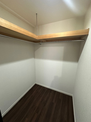 【収納】 | 千里中央エアヒルズ | 洋室6.5帖のWIC。洋服を折り畳まずに収納可能なハンガーパイプ付き！大きなキャリーケースなどもたっぷり収納可能です。