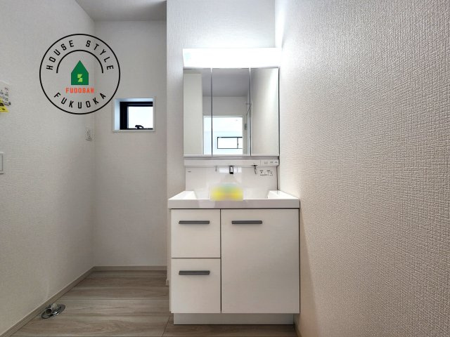 福岡市東区千早2丁目第5-2棟(2号棟)の内観：施工例|毎日使うものだから清潔な空間を保ちたい水回り。洗面にはそんな願いを解消させてくれる収納アイデアが満載です。三面鏡の裏側にはキャビネットが現れ小物から背の高い物まで収納できます。