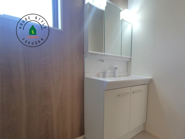 那珂川市今光8丁目第3-2棟（1号棟）の内観：施工例|毎日使うものだから清潔な空間を保ちたい水回り。洗面にはそんな願いを解消させてくれる収納アイデアが満載です。三面鏡の裏側にはキャビネットが現れ小物から背の高い物まで収納できます。