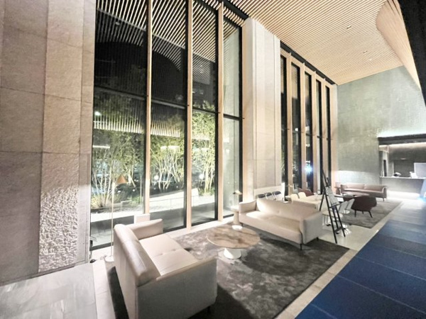 【エントランス】 | 【エントランス】伸びやかな二層吹き抜けの迎賓空間。
天井まで届くガラスウォールから自然光が降り注ぐ、明るいラウンジ空間。
ラグジュアリーなソファで寛ぎながら、窓の外に広がる庭園を眺められます。