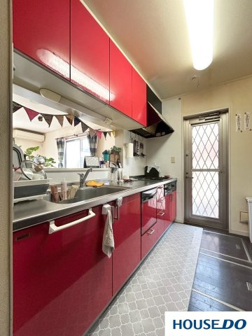 中古戸建　足利市山川町のキッチン|キャビネットの鮮やかな赤色が、空間全体に明るさと活気を与えています。料理をするのが楽しくなりそうな、気分が上がる色使いです。
調理の動線がシンプルで作業がしやすそうです。