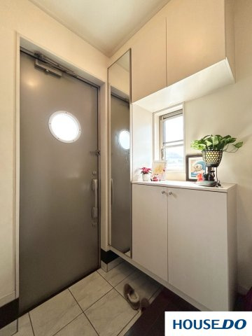 中古戸建　足利市山川町の玄関|明るく清潔感のあるデザイン：全体的に白を基調としており、明るく清潔感にあふれた玄関です。
ドアの丸い窓が船の窓のようで、ユニークでおしゃれなアクセントになっています。