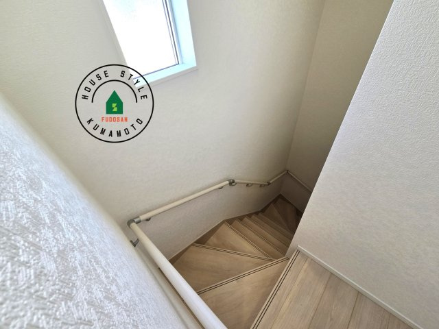 宇土市栗崎町第1₋3棟(3号棟)の内観：施工例|＜手すり付階段＞手すりがないと階段の昇り降りで危険なことはもちろん、壁に手をつきながら歩くことで壁紙が汚れやすくなります。すべての方に快適に昇り降りしていただくため、手すりを設置しました。