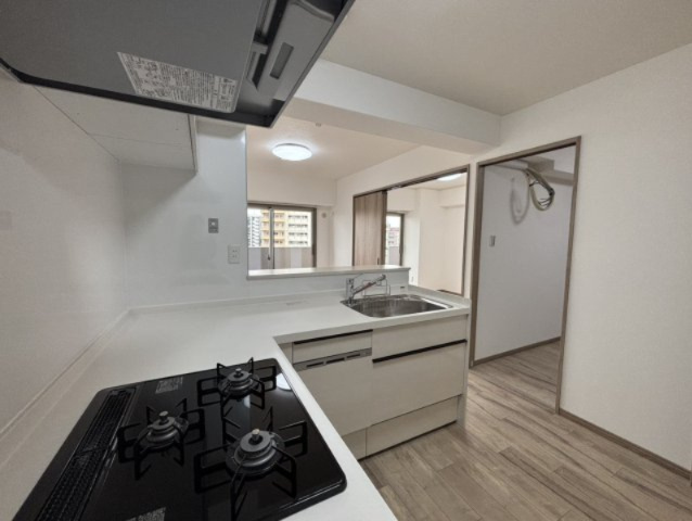 朝日プラザ長堀西のキッチン|効率良く作業ができるL字型キッチンが採用されています。食器洗浄乾燥機や3口コンロなど、家事の時短に繋がる設備が搭載されたキッチンです。上部吊戸棚や下部の引き出し収納など、収納も豊富です。