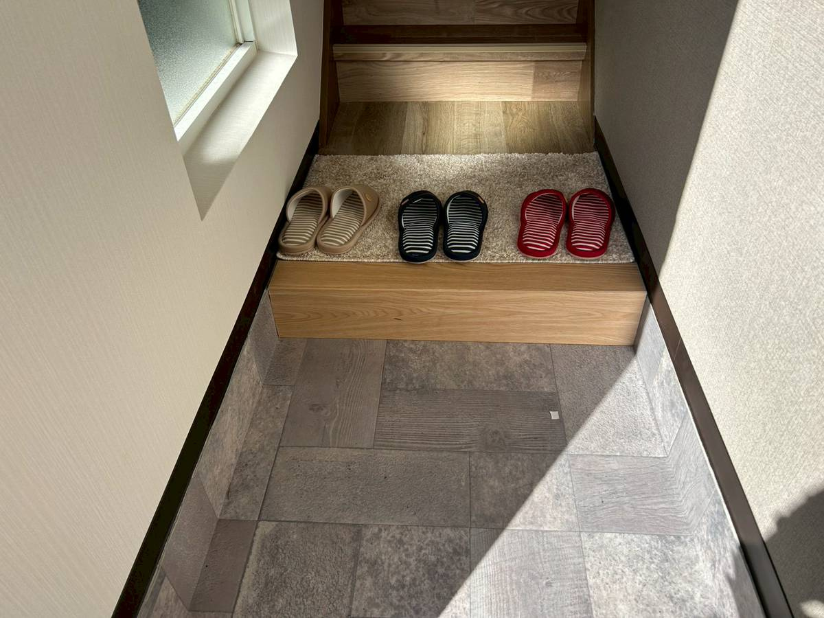 長岡京市長岡天神5丁目の玄関|玄関土間はグレー系のタイル調に仕上げられ、素敵な空間です。