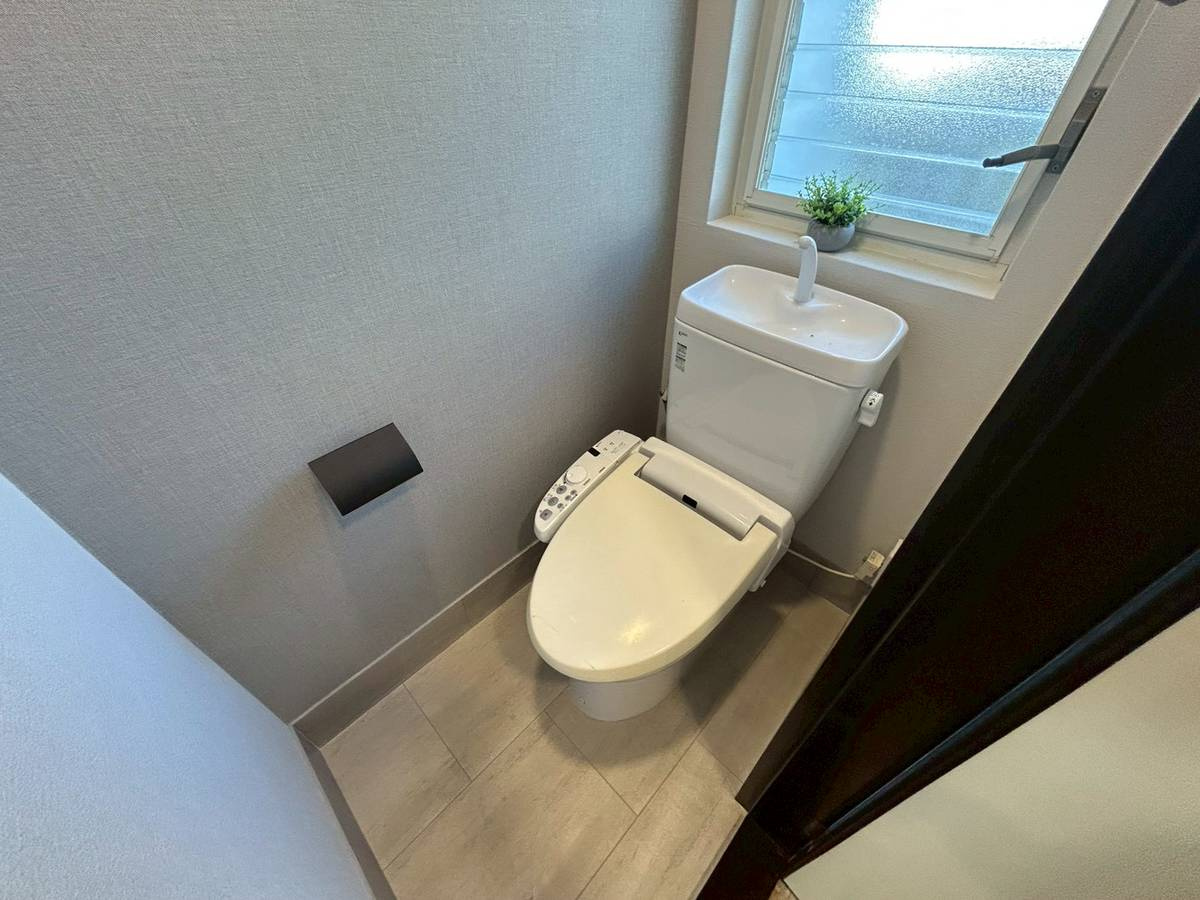 長岡京市長岡天神5丁目のトイレ|トイレにはグレー系のアクセントクロスが貼られています。アイアン調のペーパーホルダーがアクセントに◎