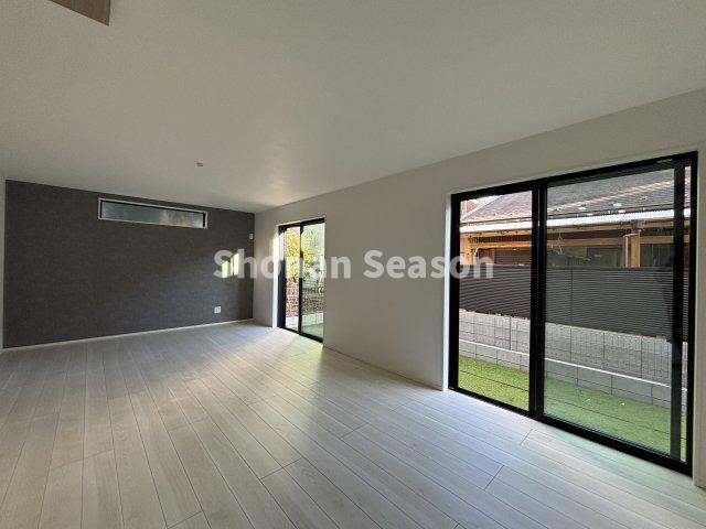 【居間・リビング】 | 人工芝が敷かれた庭が隣接し、開放感あふれるリビングが広がります。