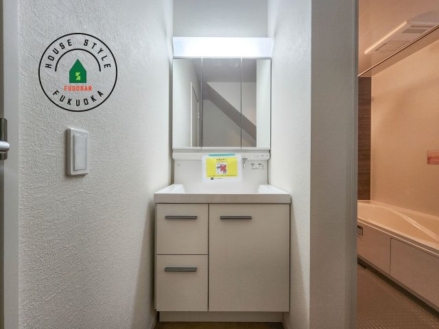 春日市大谷5丁目第4-2棟（1号棟）　の内観：施工例|毎日使うものだから清潔な空間を保ちたい水回り。洗面にはそんな願いを解消させてくれる収納アイデアが満載です。三面鏡の裏側にはキャビネットが現れ小物から背の高い物まで収納できます。