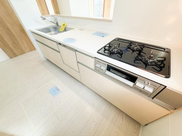 小中島3丁目1期1号棟のキッチン|キッチン内は明るい色調でまとめられており空間が広く感じられます。2つの窓があり日差しや換気にも配慮されています。シンプルなデザインで手入れがしやすい点も特徴です。動線がスムーズな配置になっています。