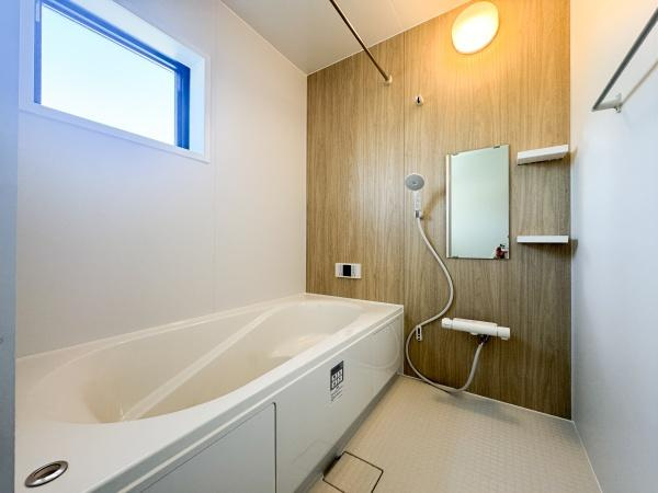 大字光吉5期1号棟の独立洗面台|洗面台は収納スペースが充実しており小物の整理に便利です。壁のストライプ柄が空間のアクセントになっています。明るい採光が室内全体をすっきりと見せます。浴室への動線もスムーズにつながっています。