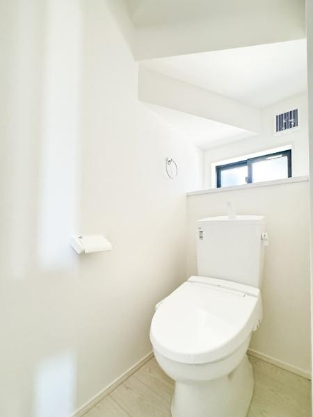 大字光吉5期1号棟のトイレ|明るい空間で清潔感のあるトイレです。白を基調としており空間に広がりを感じられます。小窓から外光が差し込み換気にも配慮された設計です。無駄のないシンプルな内装が特徴です。