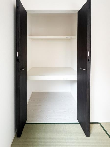 大字光吉5期1号棟の収納|開放感のあるクローゼットで収納スペースがしっかり確保されています。可動棚が設置されているため整理がしやすい設計です。和室と調和したデザインで落ち着いた雰囲気を演出します。