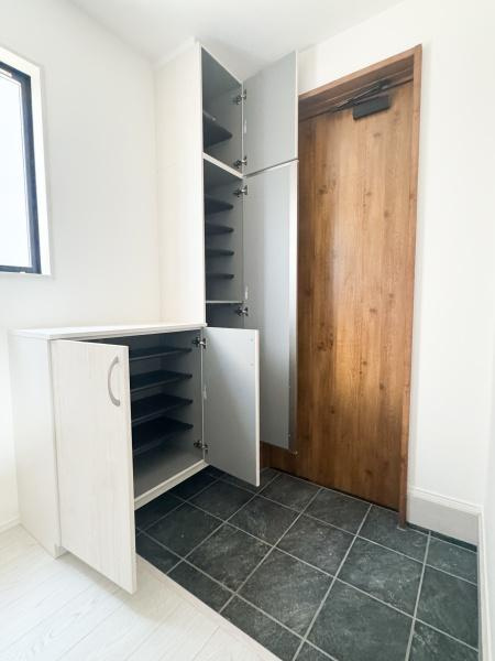 大字光吉5期1号棟の玄関|玄関は明るく開放感のある空間です。大きな鏡付きの収納も設置され使い勝手に配慮されています。シンプルなデザインがすっきりとした印象を与えます。タイルフロアと木目調の床の組み合わせが上品です。