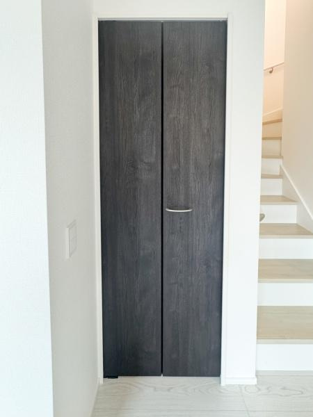 大字光吉5期1号棟の収納|シンプルなデザインの扉が空間に調和しています。収納スペースとして使いやすく出し入れもスムーズです。ダークカラーの扉が空間を引き締めています。廊下横に配置されているため動線上でも活用しやすい収納です。