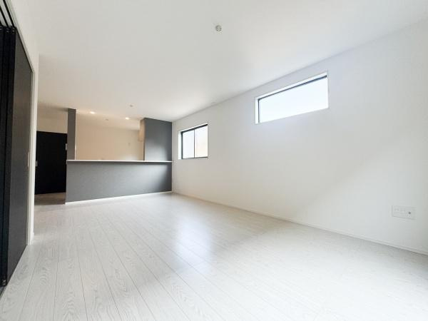 大字光吉5期1号棟の居間・リビング|リビングには大きな窓があり室内に明るさが広がります。ホワイトトーンの床が清潔感を演出しています。キッチンとの一体感も魅力的に感じられます。広々とした空間がさまざまな使い方を可能にします。