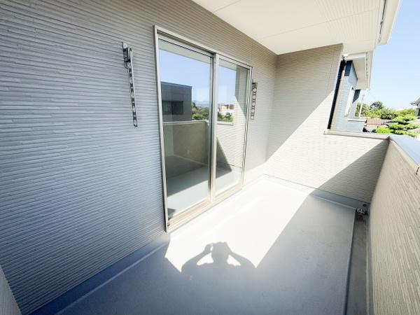 大字小池原1期3号棟のバルコニー|陽当たりの良いバルコニーが魅力です。シンプルなデザインで使いやすい空間となっています。周囲の景色も楽しめる作りです。広々としたスペースが確保されています。室内とのつながりも感じられます。