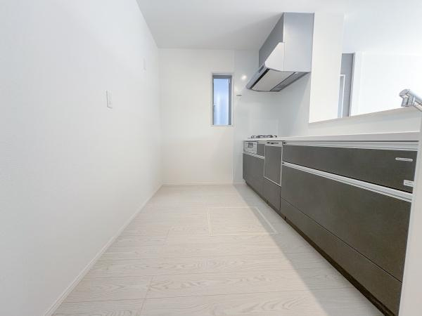 大字小池原1期3号棟のキッチン|ホワイトを基調とした明るいキッチンです。窓が設けられており自然光がしっかり入ります。すっきりとした直線的なデザインが特徴です。収納スペースも豊富です。お手入れがしやすい設備が整っています。