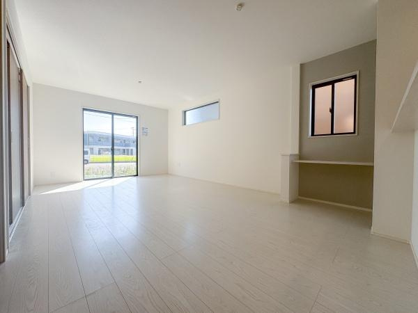 大字小池原1期2号棟の居間・リビング|リビングはナチュラルな色合いの床で落ち着いた空間です。明るい雰囲気が広がります。ドアや壁面もシンプルですっきりとした印象の使い勝手が良いリビングです。