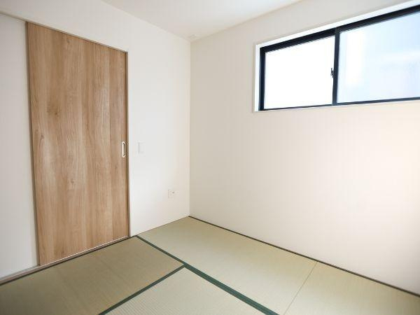 大字光吉4期2号棟の和室|明るい採光が魅力の和室です。シンプルなデザインで落ち着いた雰囲気が漂います。木目調の引き戸が空間にやさしいアクセントを加えています。畳の香りを感じられる空間です。使い勝手の良い窓付きです。