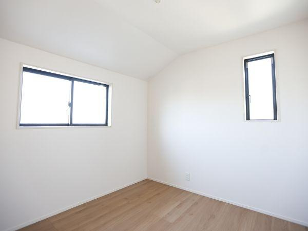 大字光吉4期2号棟の洋室|天井が高く開放感のある洋室です。二つの窓から自然光が入り明るい空間を演出します。シンプルな内装でさまざまなレイアウトに対応しやすいです。明るい床材が清潔感を感じさせます。コンセントの配置も便利です。