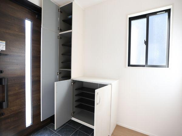 大字光吉4期2号棟の玄関|玄関には収納スペースがしっかり確保されています。窓から自然光が入り明るい印象の空間です。靴収納が上下に分かれており整理整頓しやすい設計です。シンプルなデザインで様々なインテリアに合わせやすいです。