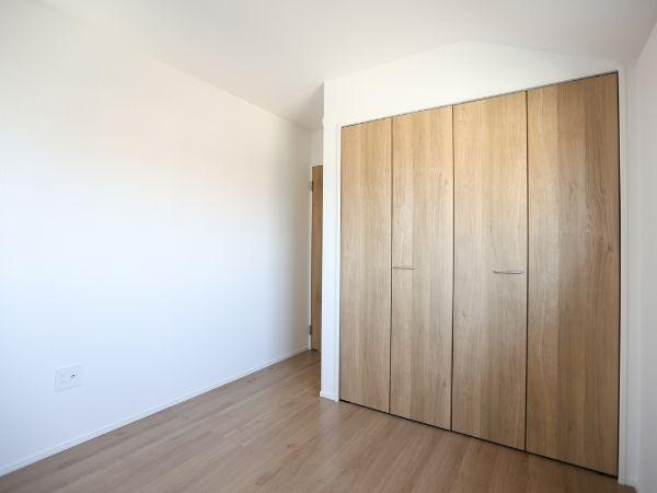 大字光吉4期2号棟の洋室|シンプルな内装ですっきりとした印象の洋室です。木目調のクローゼットが空間に温かみを加えています。床材も明るく清潔感のある雰囲気です。収納スペースが確保されており室内を有効に使えます。