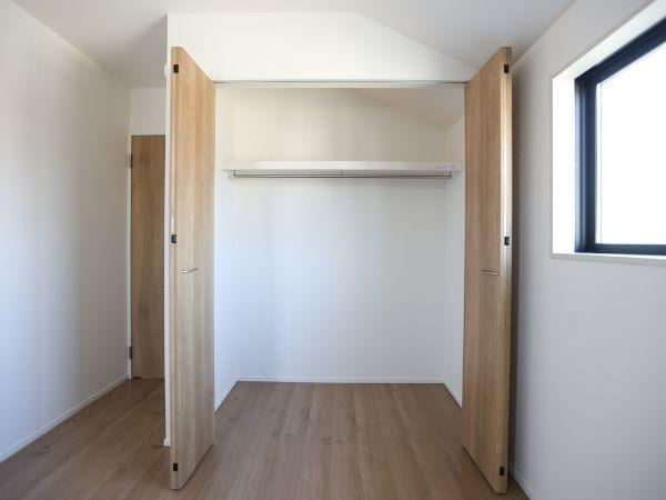 大字光吉4期2号棟の収納|シンプルなデザインの収納スペースが確保されています。木目調のドアが空間になじみ使い勝手も良好です。明るい窓のある部屋に設置されているため収納部分の湿気対策にも配慮されています。