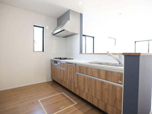 大字光吉4期2号棟のキッチン|木目調のデザインが魅力のキッチンです。明るい空間に窓があり換気にも配慮されています。広々とした作業スペースが確保されています。収納も充実していて便利です。シンプルで使いやすいレイアウトになっています。