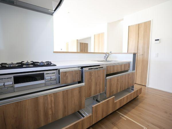 大字光吉4期2号棟のキッチン|木目調のデザインが印象的なキッチンです。収納スペースが豊富ですっきりとした印象を与えます。広々としたカウンターは使い勝手が良さそうです。