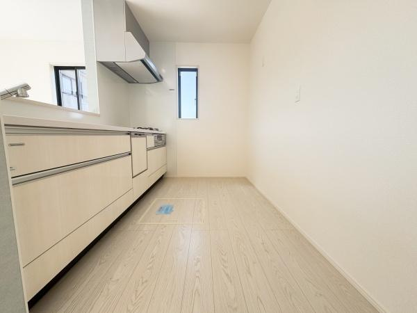 大字小池原1期1号棟のキッチン|明るい空間が特徴のキッチンです。収納がしっかりと確保されており使い勝手の良いレイアウトとなっています。ナチュラルな色合いの床とシンプルなデザインが調和しています。窓からの自然光が入るのもポイントです。