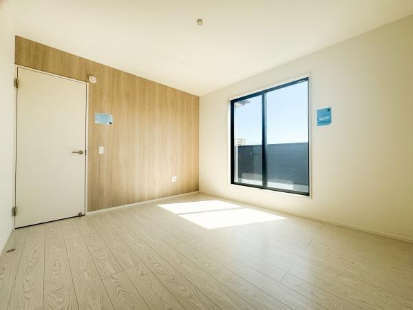 大字小池原1期1号棟の寝室|大きな窓からたっぷりと自然光が差し込む明るい寝室です。シンプルな内装で落ち着いた雰囲気を感じられます。壁面の木目調デザインがアクセントになっています。無駄のない空間設計で家具の配置も自由に楽しめます。