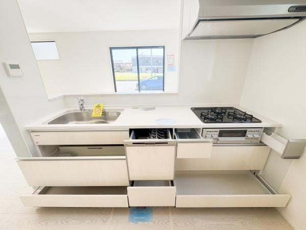 大字小池原1期1号棟のキッチン|収納スペースが豊富なキッチンです。シンクやコンロ周りも使いやすいレイアウトになっています。明るい窓が近く開放感も感じられます。シンプルなデザインが空間をすっきりと見せています。