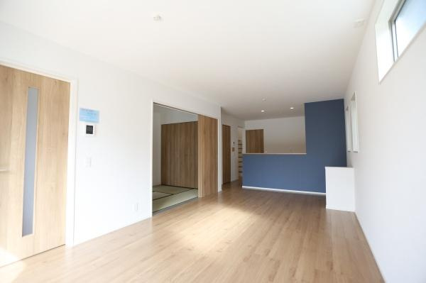 徳島2丁目1期2号棟の居間・リビング|広々としたリビングで開放感があります。大きな窓から自然光が差し込み明るい空間です。隣接の和室もスムーズに利用できる間取りになっています。床は木目調で落ち着いた雰囲気です。