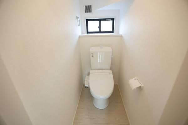 横尾東町1丁目1期2号棟のトイレ|コンパクトで使いやすいトイレ空間です。白を基調とした内装が清潔感を演出しています。小窓が設けられており換気や採光にも配慮されています。シンプルな設備でお手入れもしやすい仕様となっています。