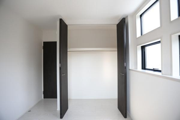 横尾東町1丁目1期2号棟の玄関|シンプルで洗練された外観の玄関が印象的です。木目調のドアがアクセントとなりモダンな雰囲気を演出しています。アプローチもすっきりとしており開放感を感じられます。明るい空間が魅力の一つです。