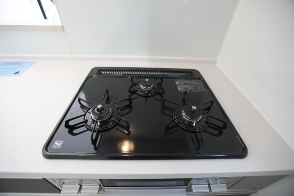 横尾東町1丁目1期2号棟のキッチン|3口コンロを備えたキッチンです。お手入れしやすいトッププレート仕様となっています。シンプルで使いやすいデザインです。全体的にすっきりと清潔感があります。