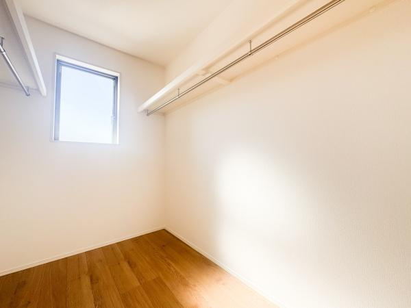 徳島2丁目1期3号棟の収納|明るい光が差し込む収納スペースです。シンプルな内装で使い勝手に配慮されています。ハンガーパイプが両側に配置されているため整理がしやすい仕様です。開放的な雰囲気が広がっています。