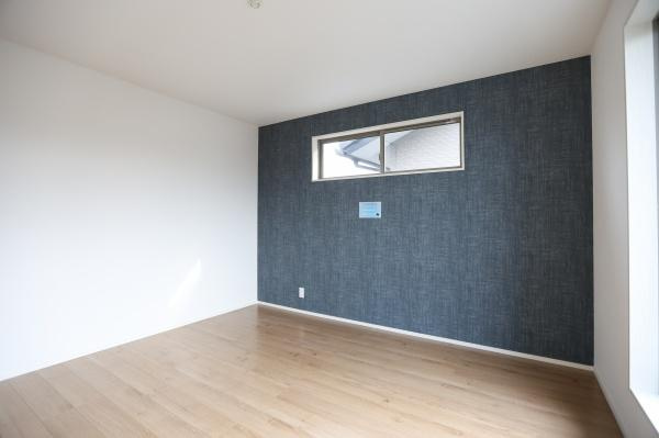 徳島2丁目1期3号棟の洋室|大きな窓からたっぷりと光が差し込む明るい洋室です。落ち着いた色合いのクロスが空間にアクセントを加えています。木目調のフローリングがすっきりとした印象を与えます。壁面の小窓もポイントです。