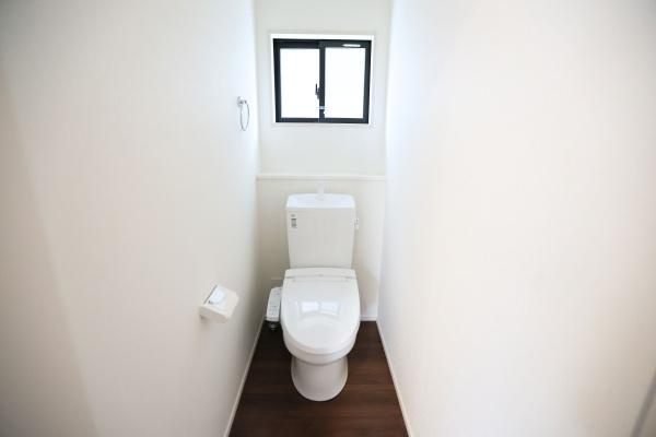 ふじが丘西1丁目1期3号棟のトイレ|トイレには窓があり換気に配慮された設計です。白を基調とした空間が印象的です。床には温かみのある木目調が使われています。手洗い部分やペーパーホルダーもシンプルにまとまっています。