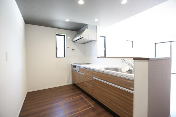 ふじが丘西1丁目1期3号棟のキッチン|窓から自然光がしっかり入る明るいキッチンです。木目調の面材が落ち着いた雰囲気を演出しています。すっきりとしたレイアウトでお手入れもしやすそうです。収納スペースも豊富に備えられています。