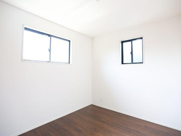 挾間町下市2期8号棟の浴室|淡い色調の壁と床で明るく清潔感のあるバスルームです。浴槽は広々としておりリラックスできる空間が確保されています。壁付きのミラーや収納棚も設置されていて実用性にも配慮されています。