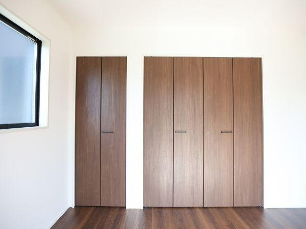 挾間町下市2期8号棟の居間・リビング|広々としたリビングは木目調の床が上品な印象を与えます。二方向の窓から光が入り明るさがしっかり確保されています。カウンターキッチンが空間にアクセントを加え開放感のある室内です。