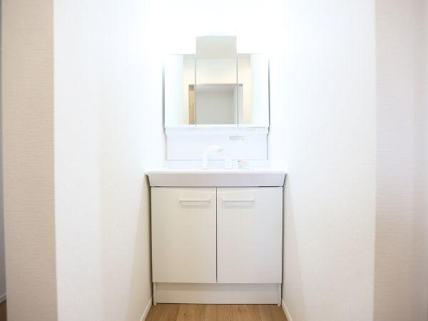 挾間町下市2期9号棟の収納|洗面台下に収納スペースがあり使いやすさが感じられます。シンプルなデザインで清潔感のある印象です。鏡の裏にも収納スペースが設けられており日用品の整理に役立ちます。